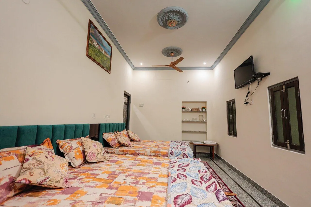 Deluxe AC two queen room with entertainment TV unit and dressing mirror at The Jawai Niwas