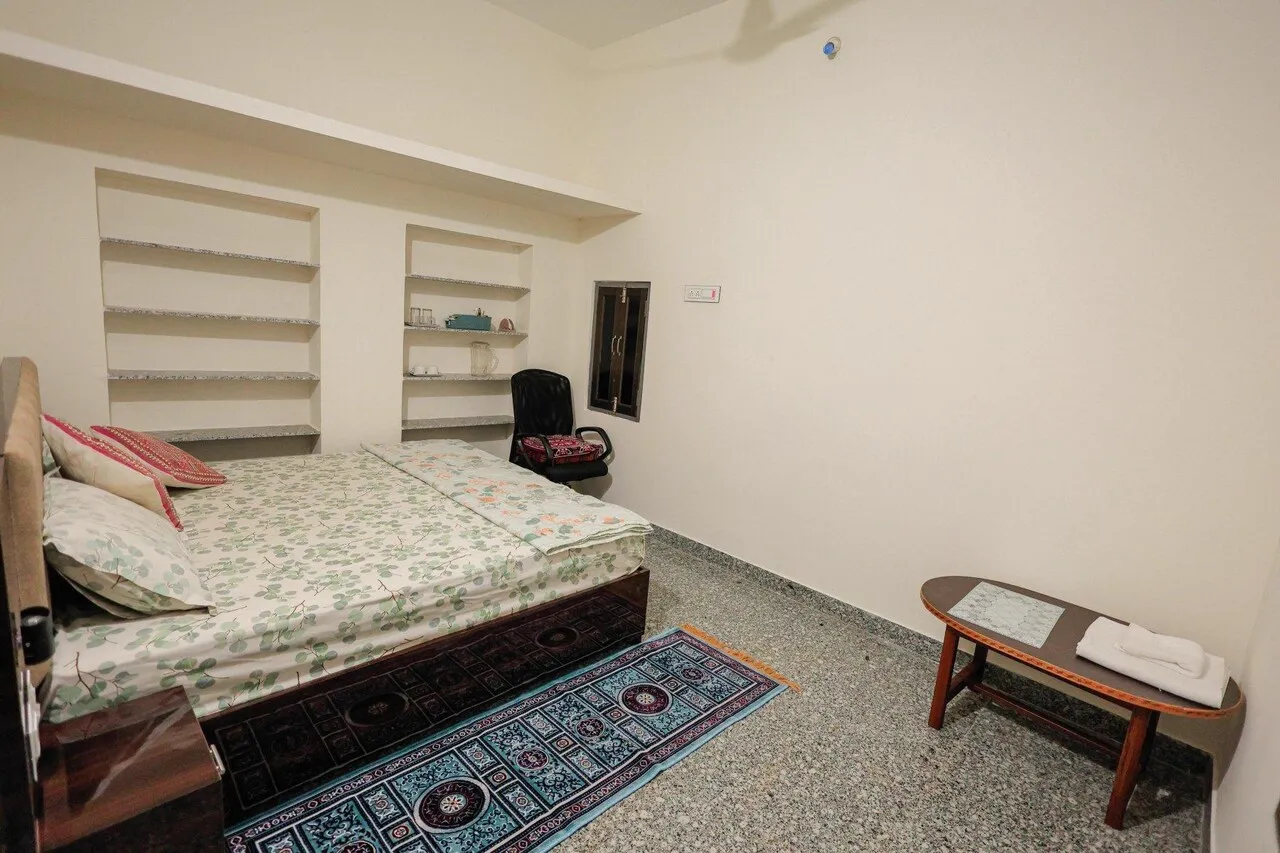 King-size bed, dressing mirror and chair in Deluxe Non-AC King room at The Jawai Niwas